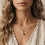 Close-up of a woman wearing a gold necklace with a pendant.