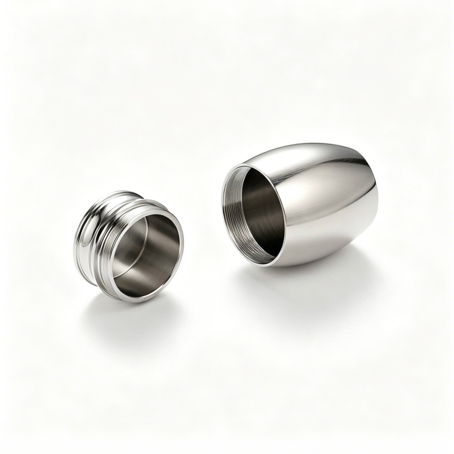 Two metallic earplugs on a white background