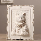 Decorative wall art of a cat with ornate frame on a wooden surface.