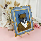 Framed artwork of a wolf wearing a suit with a flower, placed on a pink surface with decorative elements.