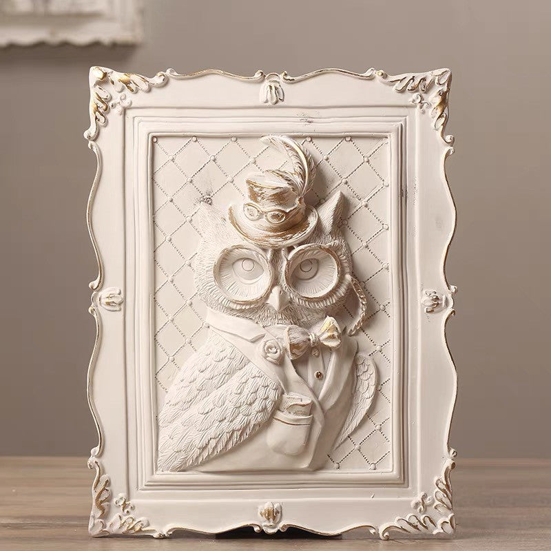 Decorative wall art of an owl in a frame with intricate detailing on a neutral background