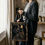 Person holding a tote bag with a cat design and 'Chasing the Sun' text in a home setting.