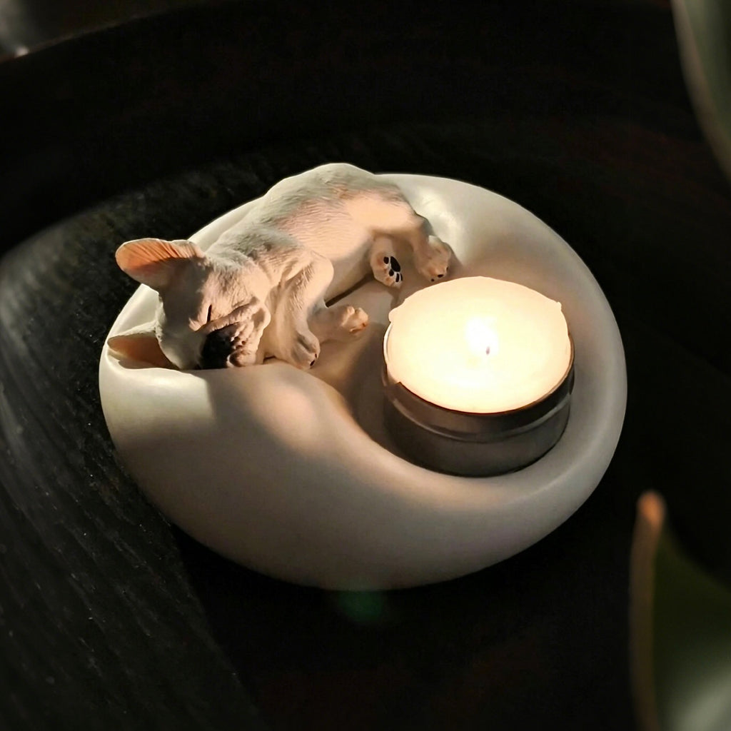 Matte white plaster sleeping French Bulldog candle holder and jewelry trinket tray with a lit tealight candle