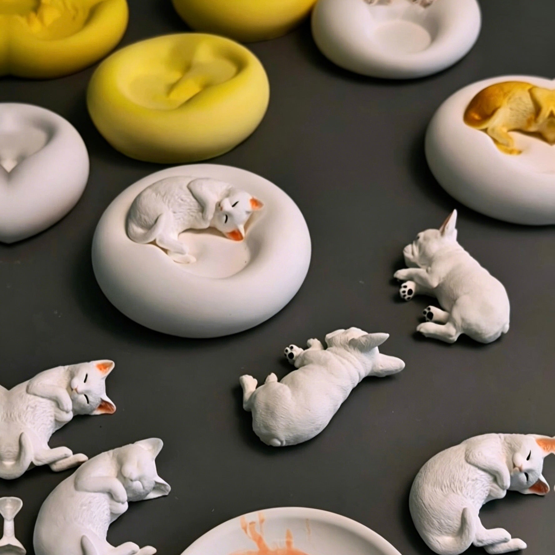 Collection of plaster pet candle holders and jewelry trays featuring sleeping French Bulldog and cat designs