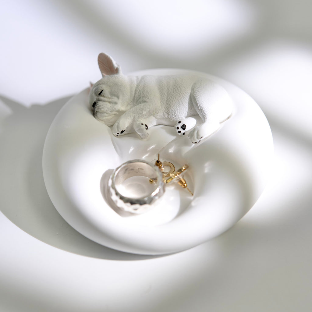 Matte white plaster sleeping French Bulldog jewelry tray and candle holder displaying a ring and earrings