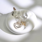 Matte white plaster sleeping French Bulldog jewelry tray and candle holder displaying a ring and earrings