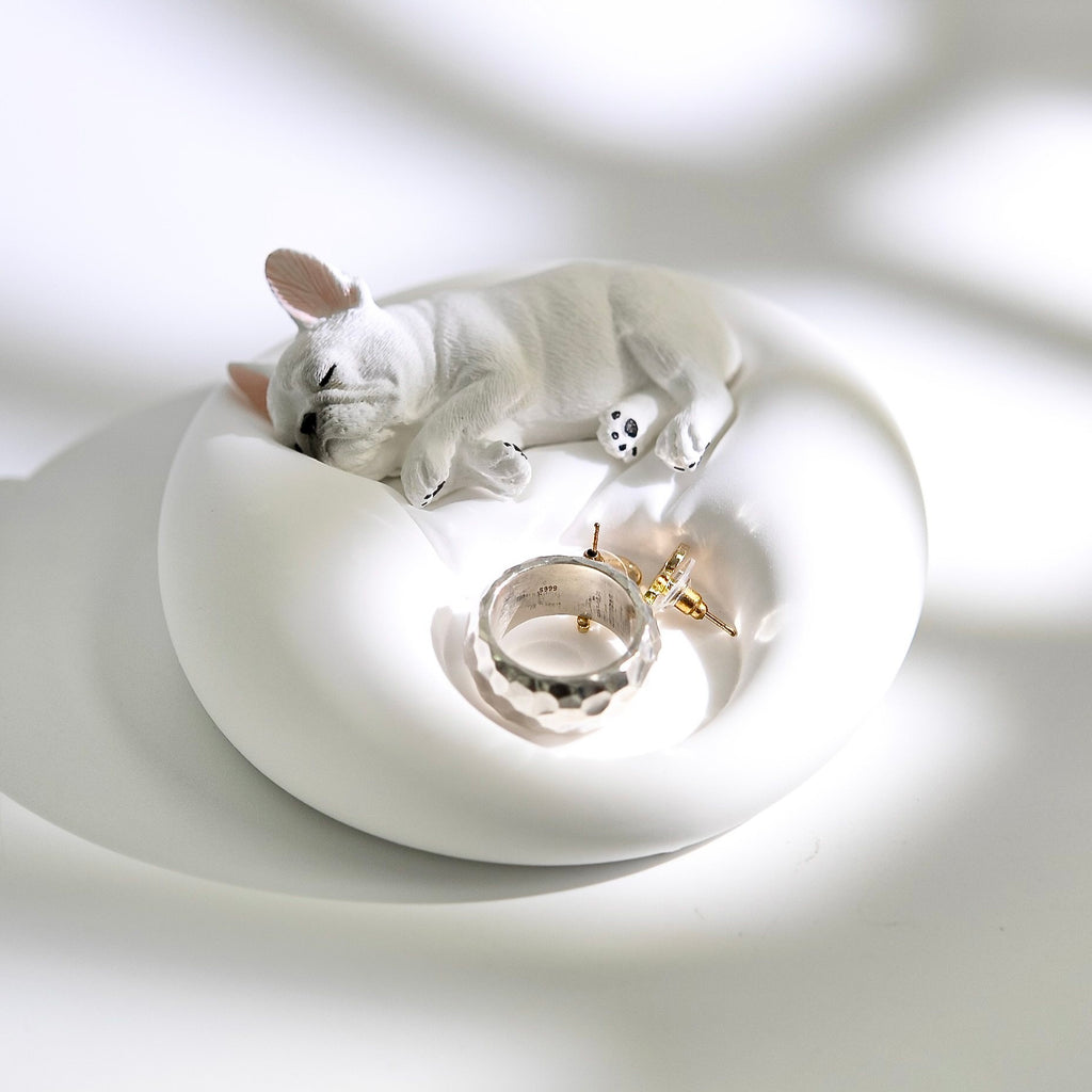 Matte white plaster sleeping French Bulldog jewelry tray and candle holder displaying a ring and earrings