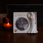 Memorial photo frame with angel sculpture and cat photo, candle in the background