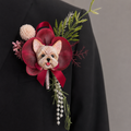 Hand-painted plaster dog wedding boutonniere lapel pin featuring a Yorkshire Terrier with red artificial flowers and dangling pearls.