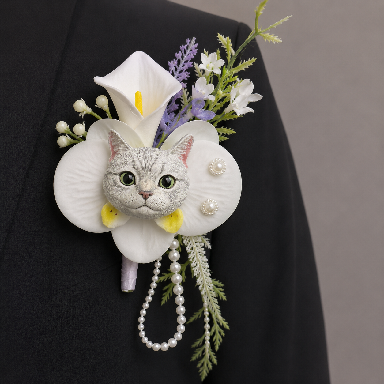 Hand-painted plaster silver tabby cat wedding boutonniere with a white calla lily, purple flowers, and dangling pearls.