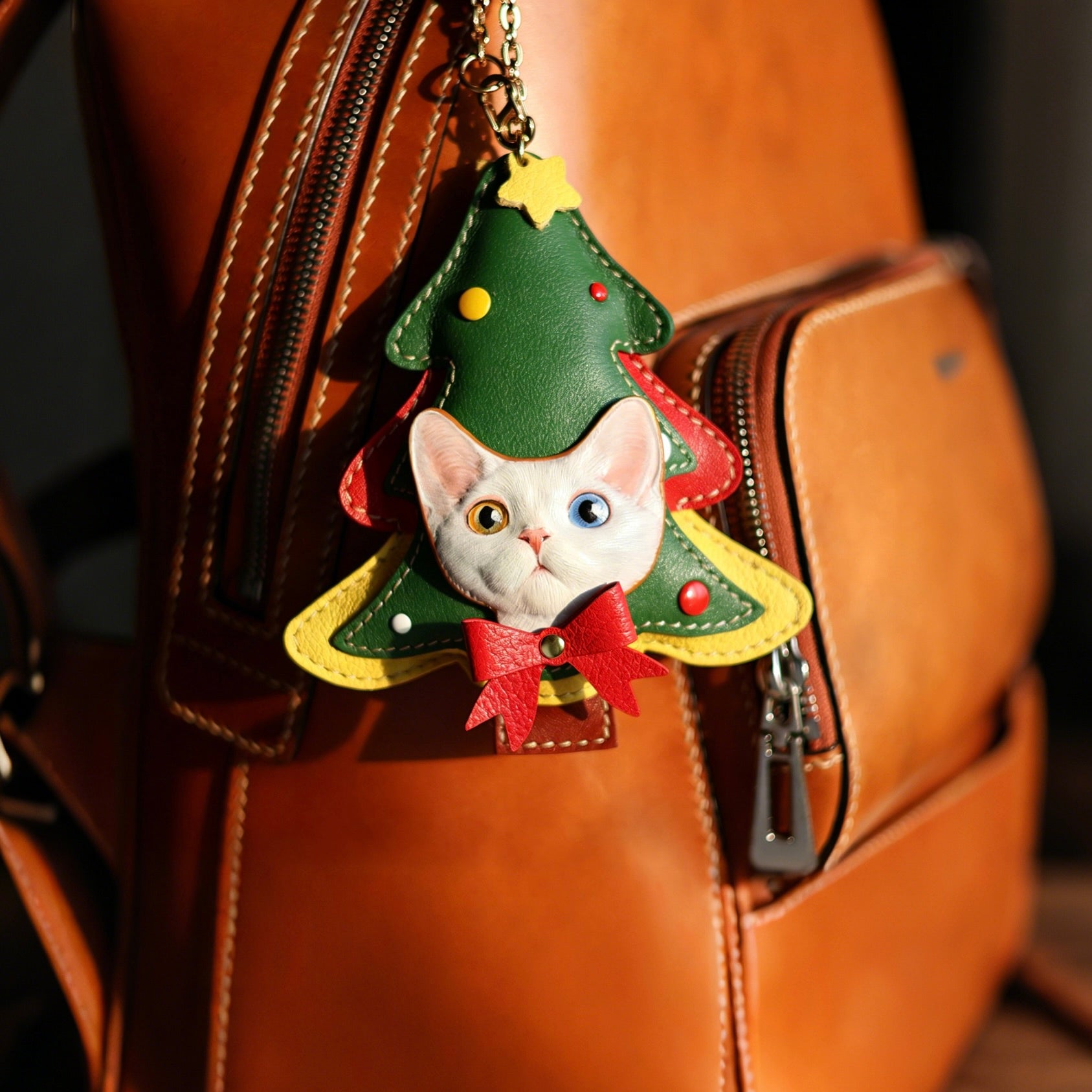 Cat-shaped Christmas tree keychain on a brown leather bag