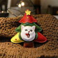 Christmas tree-shaped keychain with a cat face on a textured surface