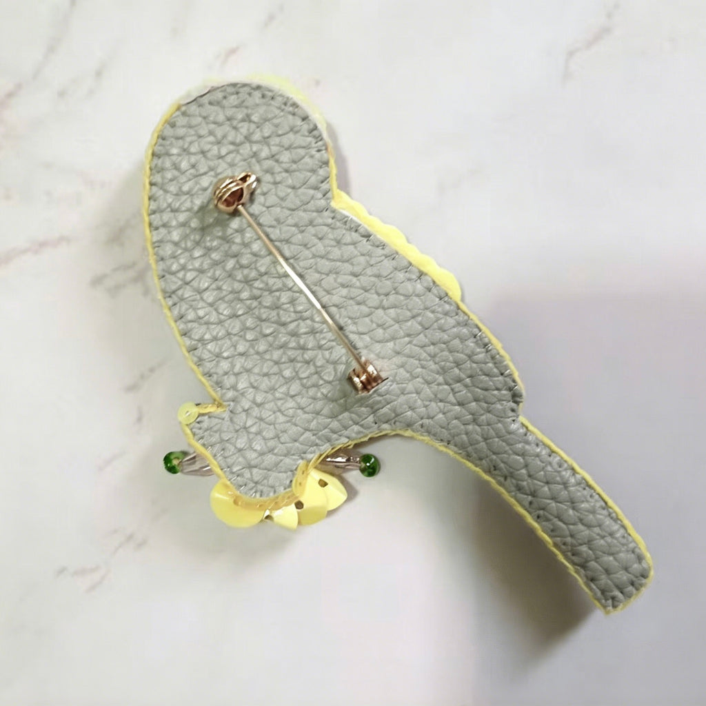 Gray textured clutch with gold and green accents on a light gray background