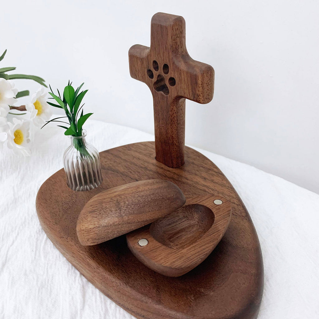 Wooden ring holder with paw print design on a white surface with flowers.