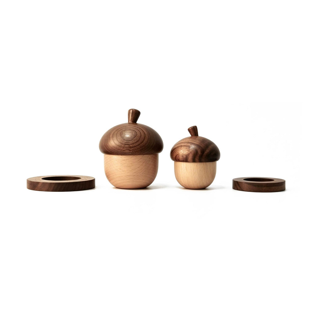 Two wooden acorn-shaped candle holders on a white background