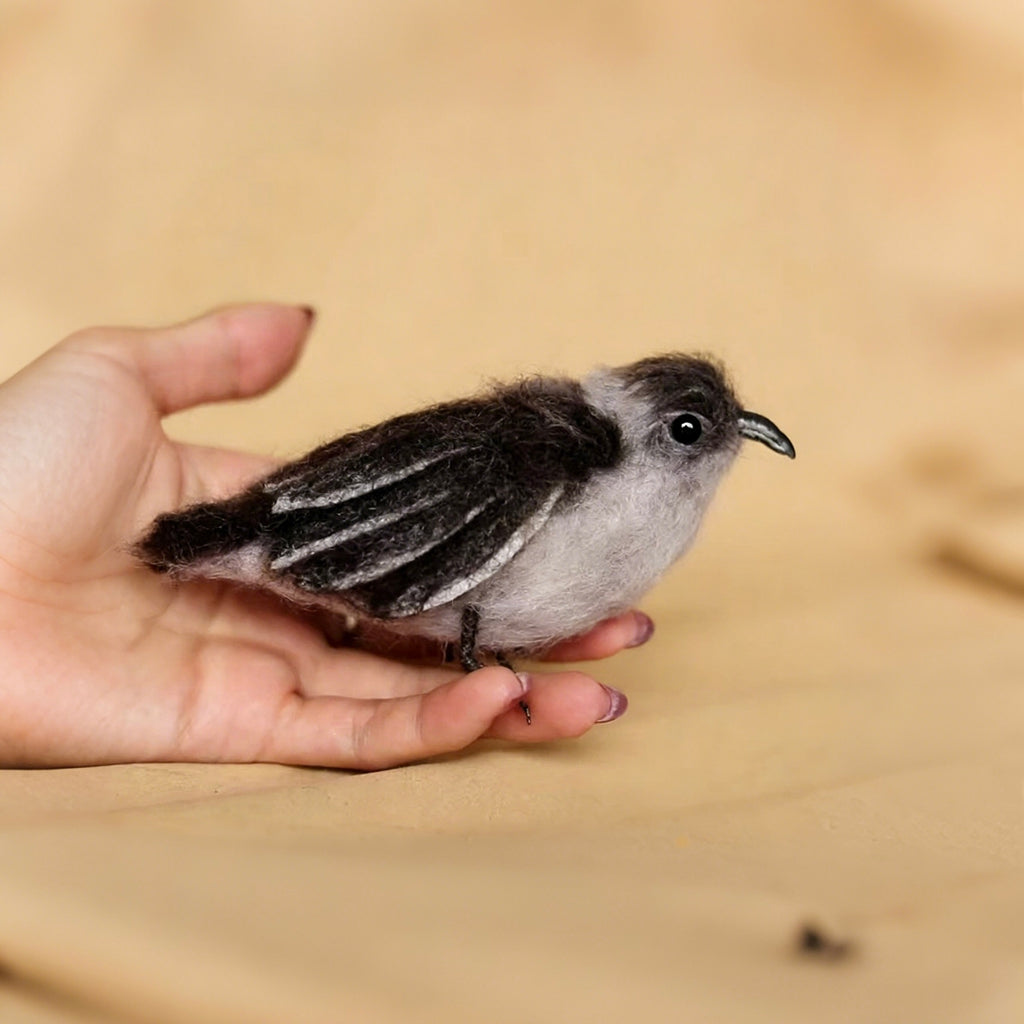 Small bird perched on a person's hand with a blurred background