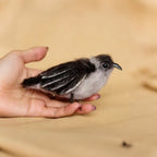 Small bird perched on a person's hand with a blurred background