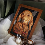 Framed artwork of two dogs on a surface with a blurred background