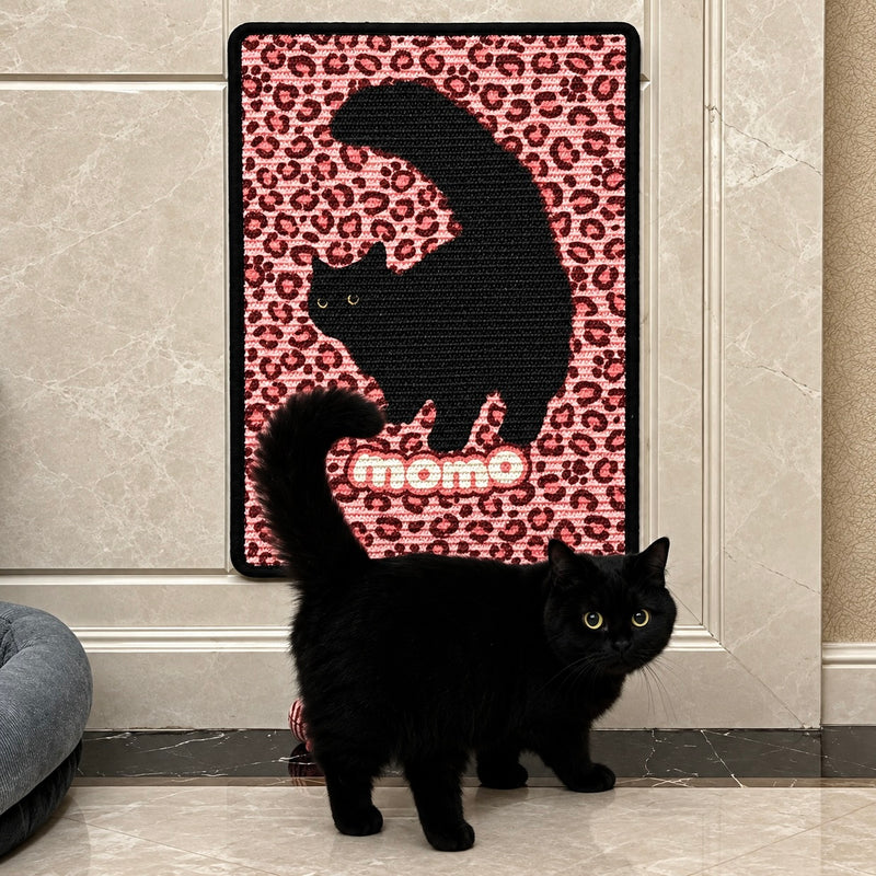 Black cat posing in front of a personalized cat portrait scratcher with a custom design