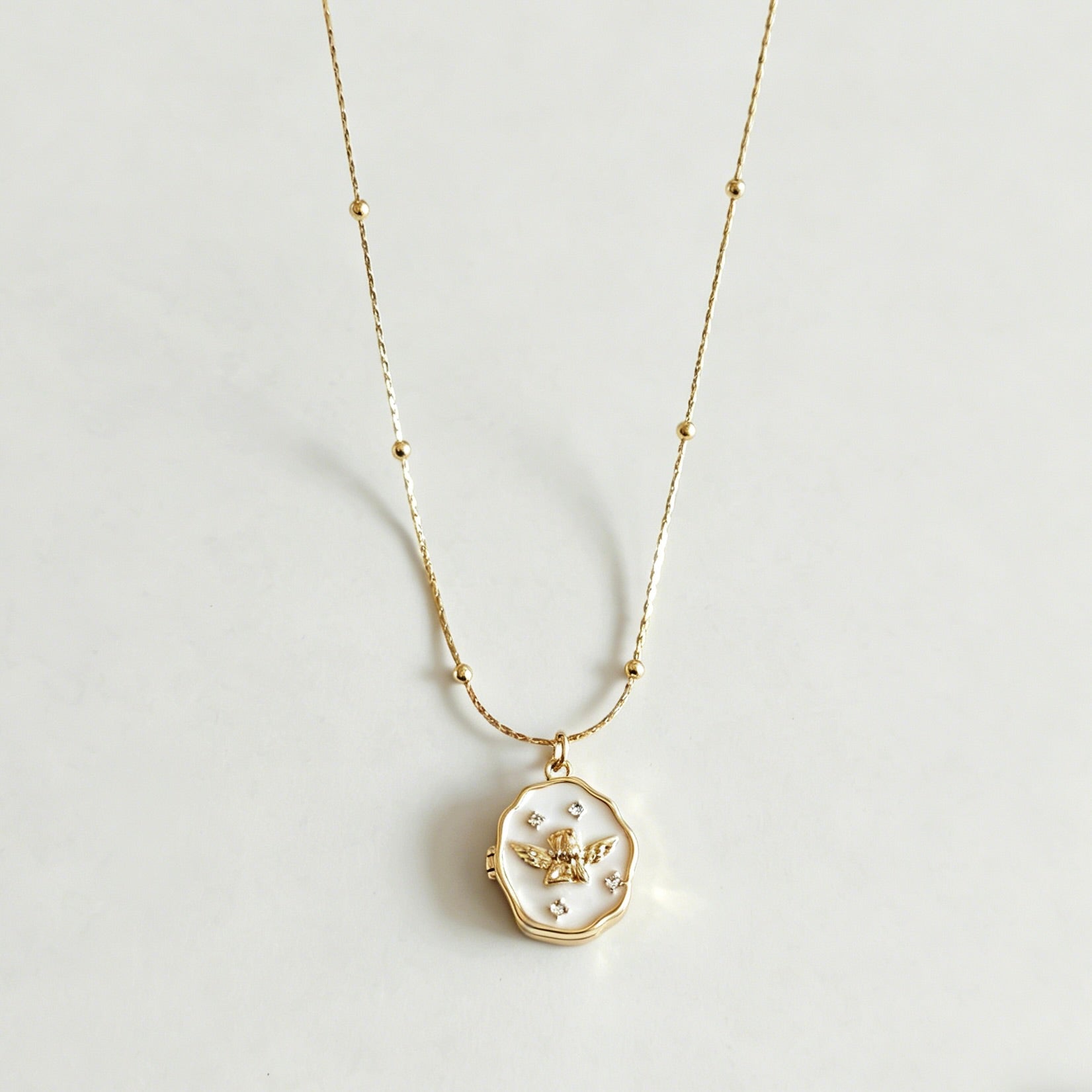 Gold necklace with a pendant on a light gray background