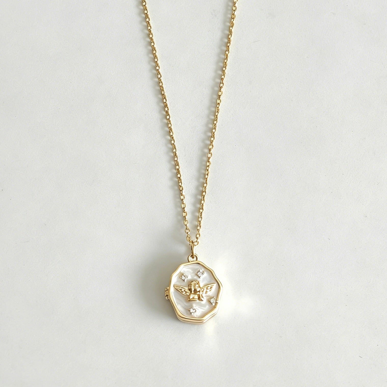 Gold necklace with a pendant on a light gray background