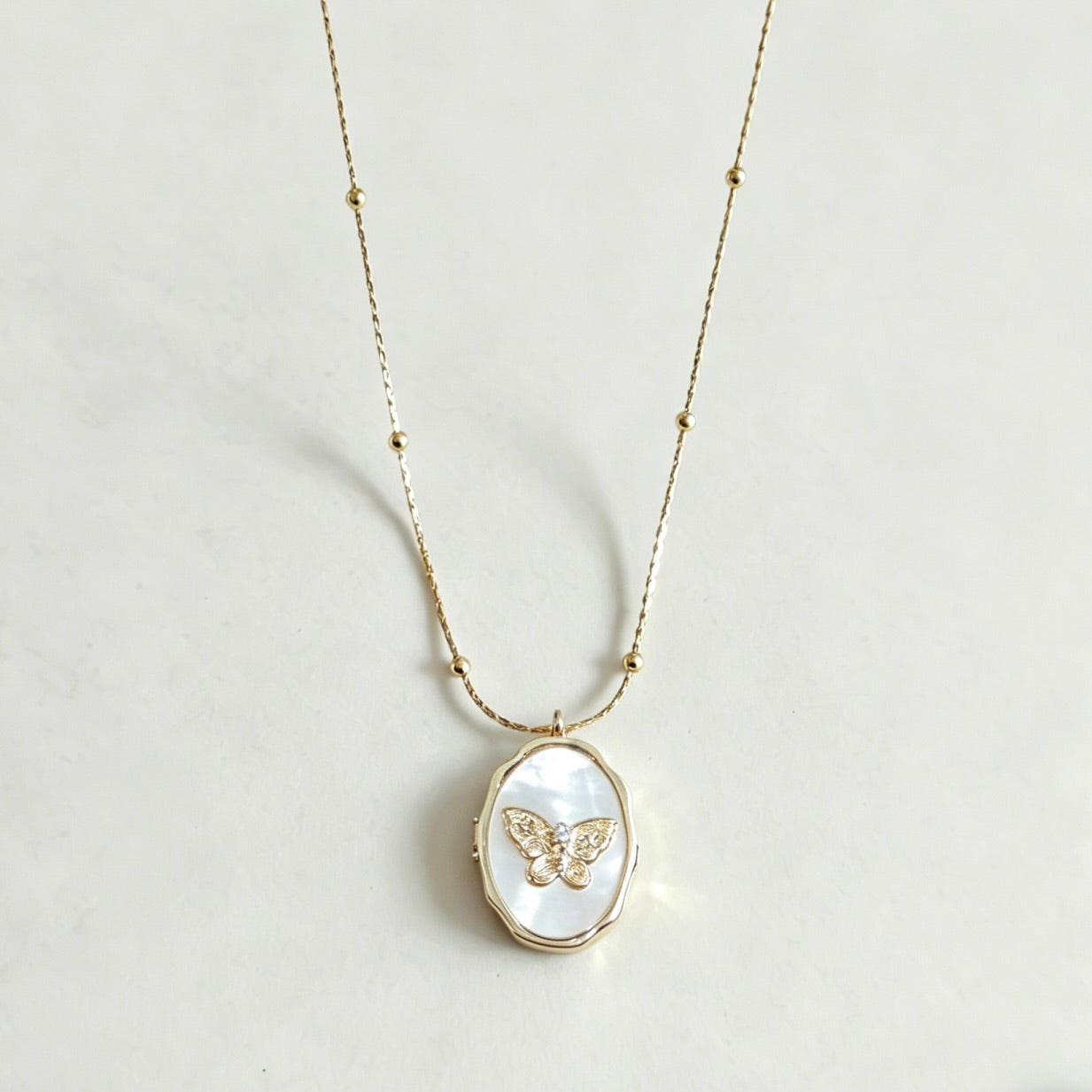 Necklace with a butterfly pendant on a light gray background