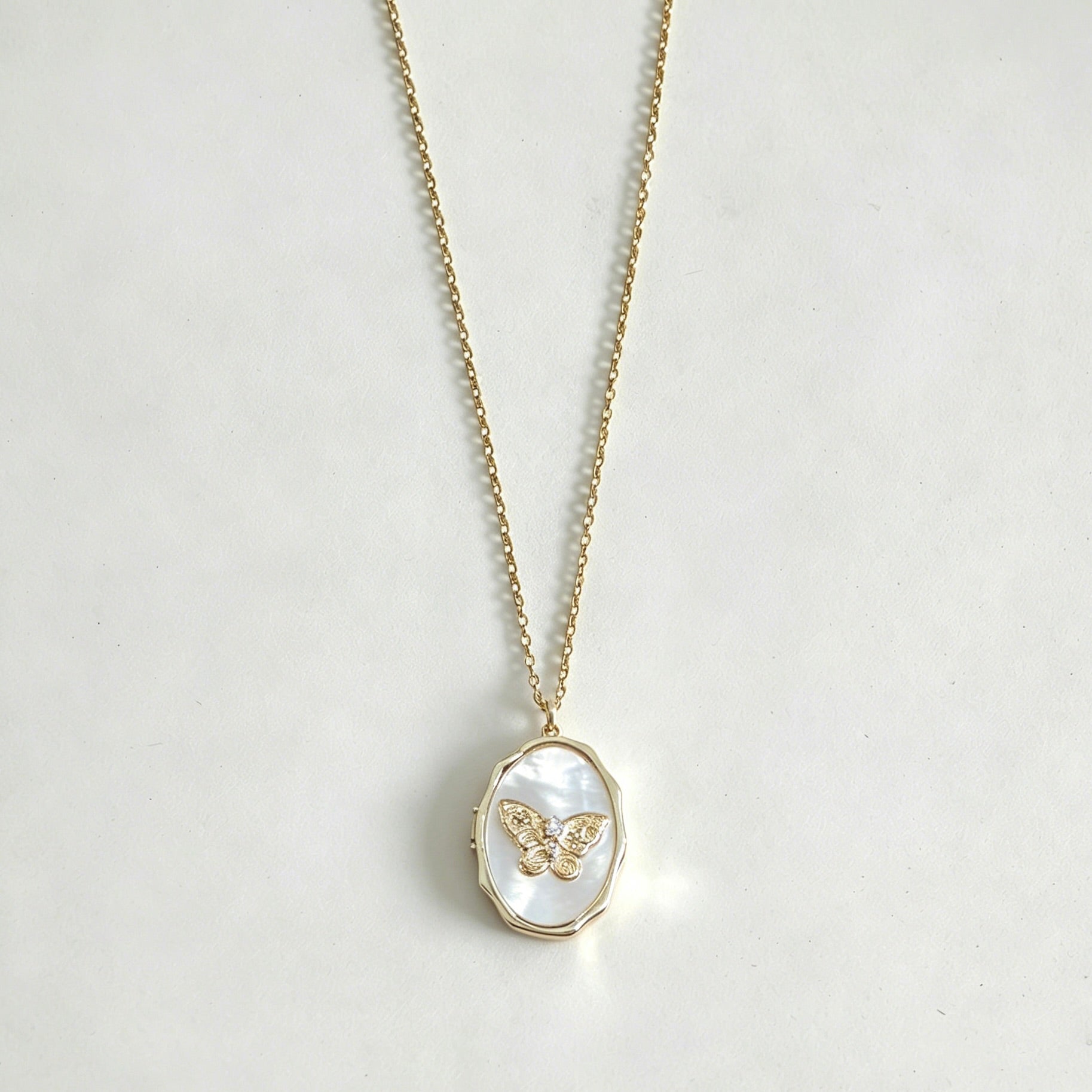 Necklace with a butterfly pendant on a light gray background