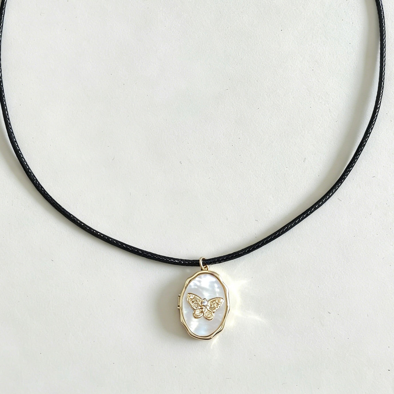 Necklace with a pendant featuring a butterfly design on a white background