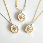 Three gold necklaces with angel pendants on a white background