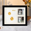 Framed pet portrait with paw prints and the name 'Mini' on a soft surface.