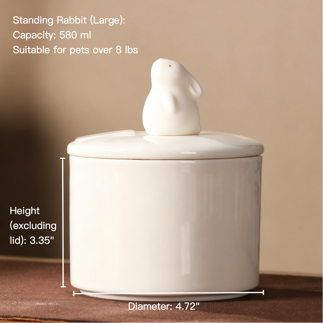 Person holding a white ceramic tea infuser with a lid on a wooden 