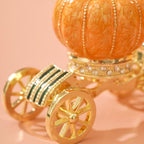 Decorative pumpkin with gold carriage wheels on a pink background