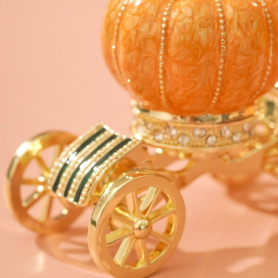 Decorative pumpkin with gold carriage wheels on a pink background