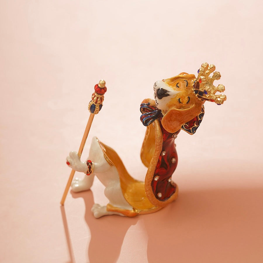 Decorative figurine of a lion with a crown and scepter on a pink background