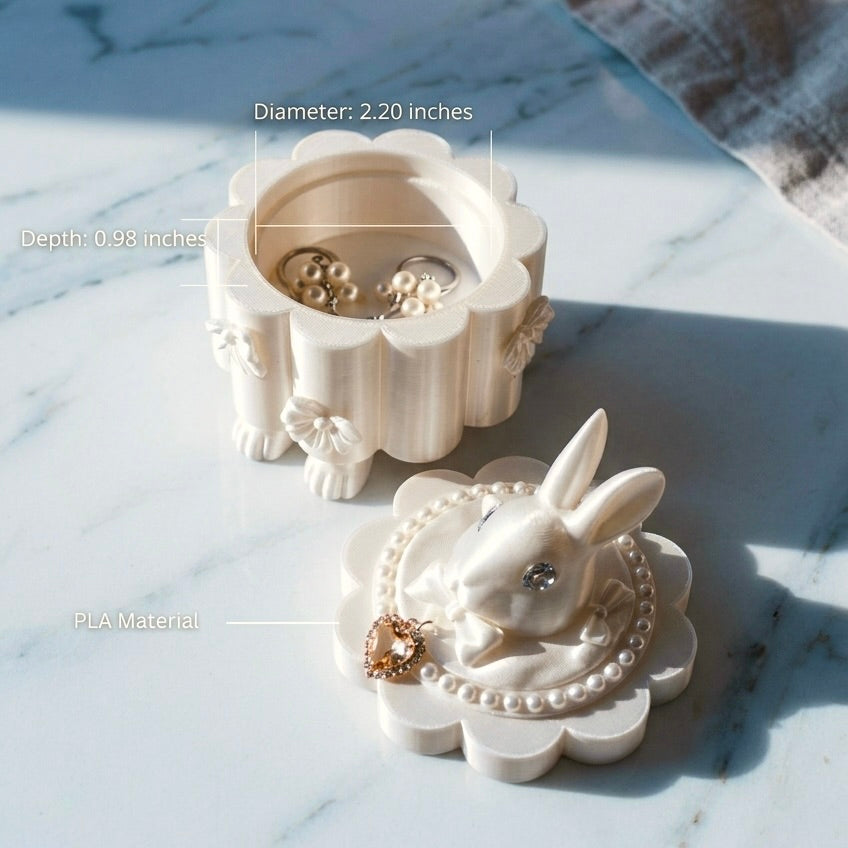 White rabbit-shaped jewelry box with earrings on a marble surface