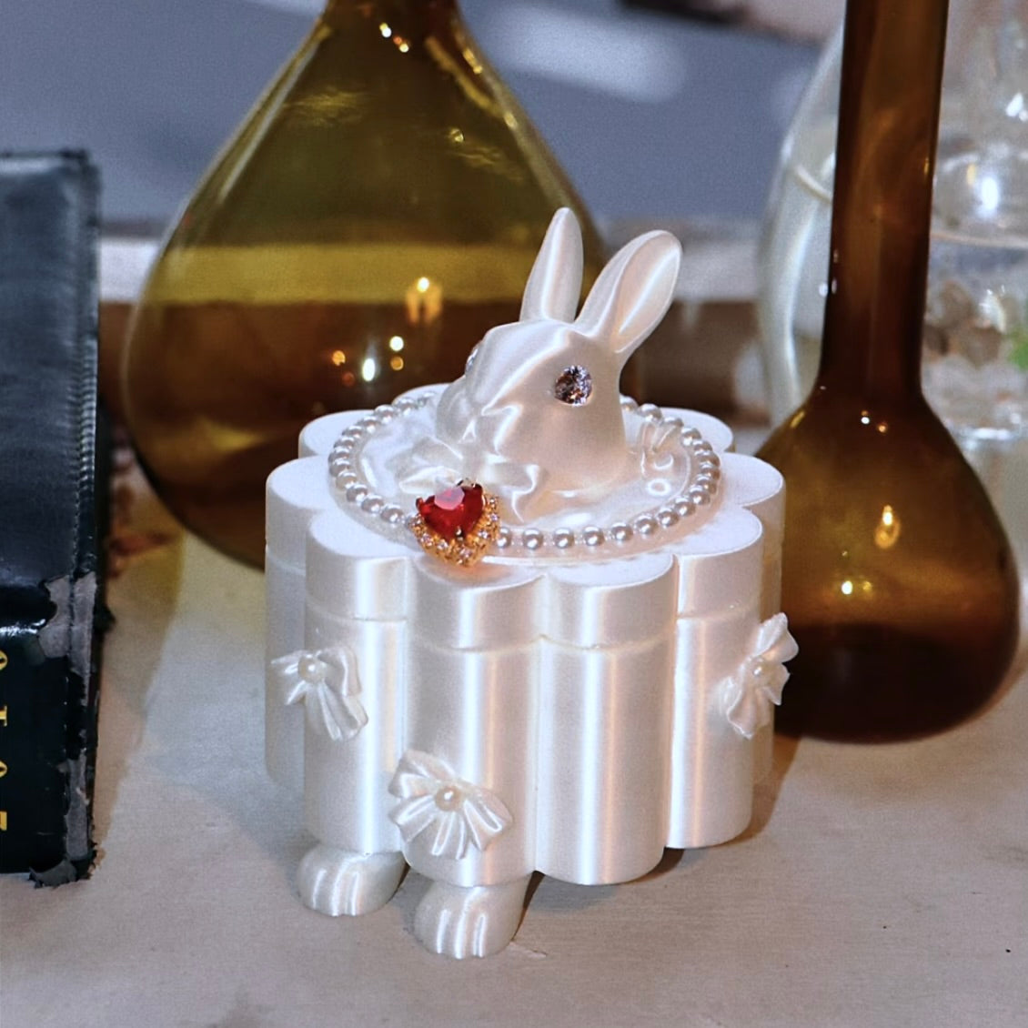 White rabbit-shaped jewelry box with decorative elements on a surface.