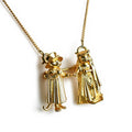 Gold necklace with two figures holding hands on a white background