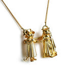 Gold necklace with two figures holding hands on a white background