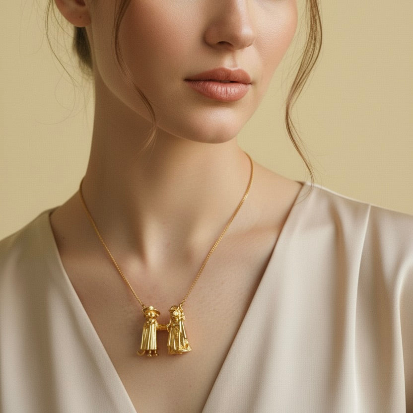 Gold necklace with pendant worn by a model against a beige background