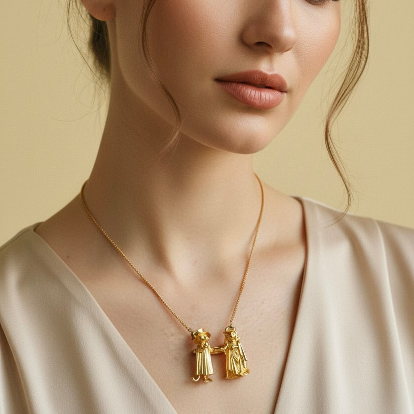 Woman wearing a gold necklace with two pendants against a beige background