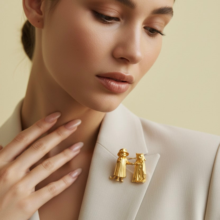 Woman wearing a gold brooch on her beige blazer against a neutral background