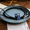 Necklace with a pendant resembling 'Starry Night' on a ceramic plate.
