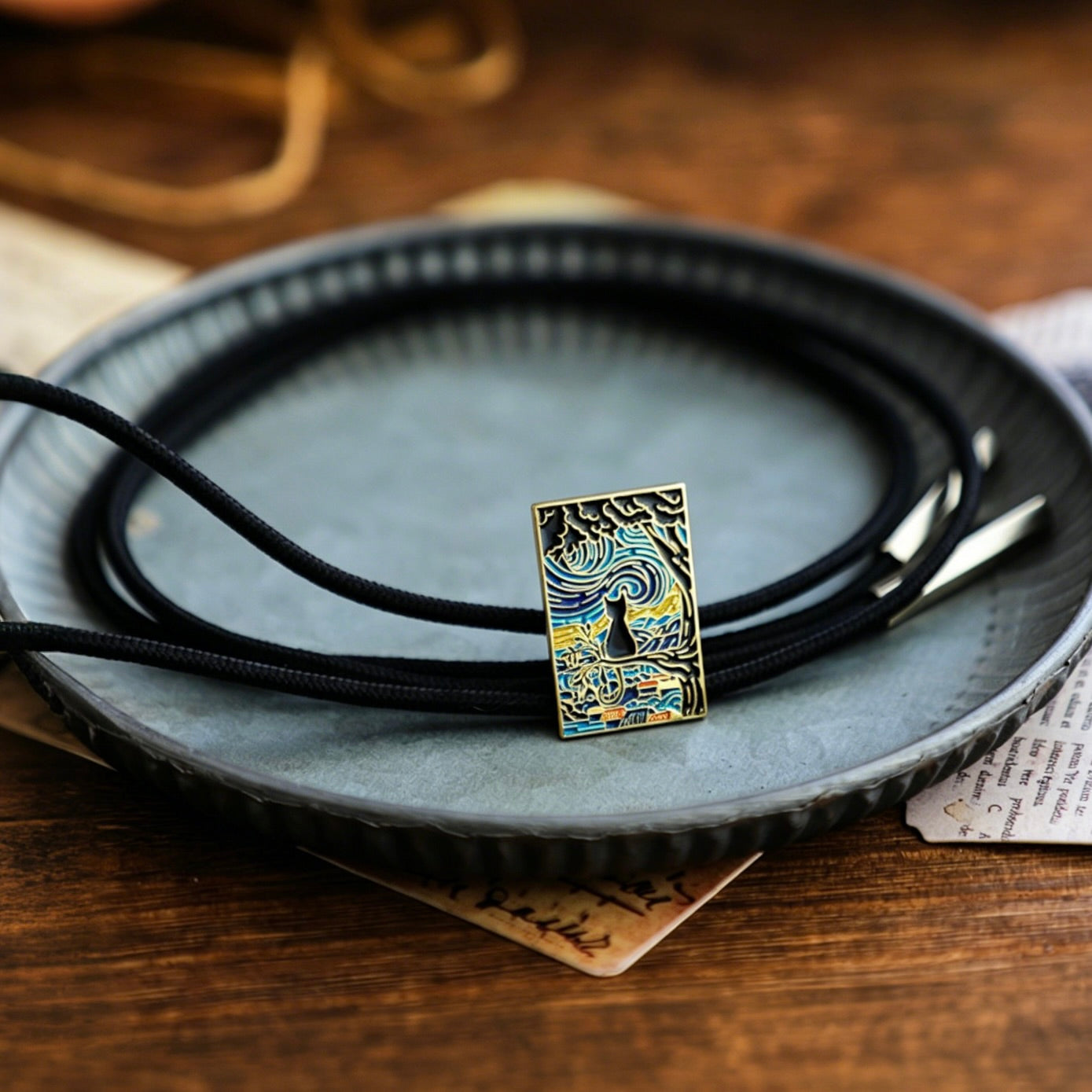 Necklace with a pendant on a dark plate on a wooden surface