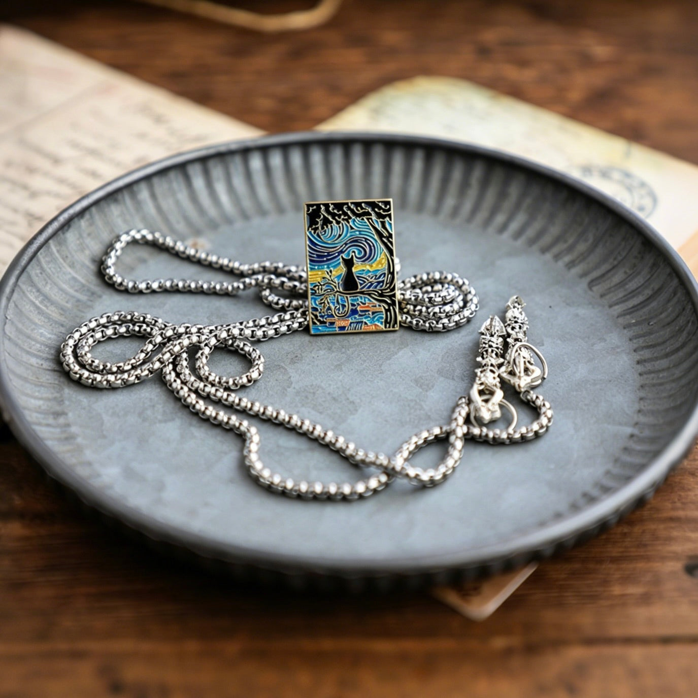 Silver necklace with a decorative pendant on a textured blue plate.
