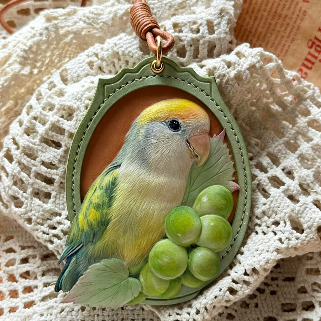 Bespoke exotic animal leather pendant keychain featuring a detailed 3D hand-carved green parrot and grapes relief design