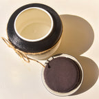 Open ceramic pet urn showing the interior and padded underside of the removable lid