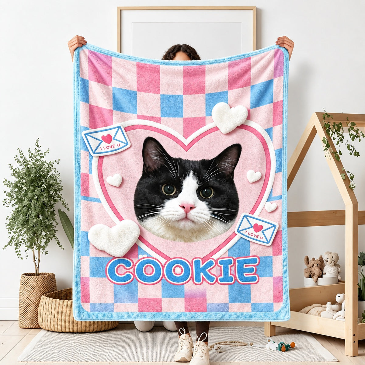 Person holding the full Cookie cat portrait blanket with pink and blue checks, hearts and envelope motifs