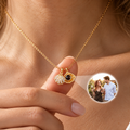Close-up of a gold-tone shell necklace projecting a personalized couple photo