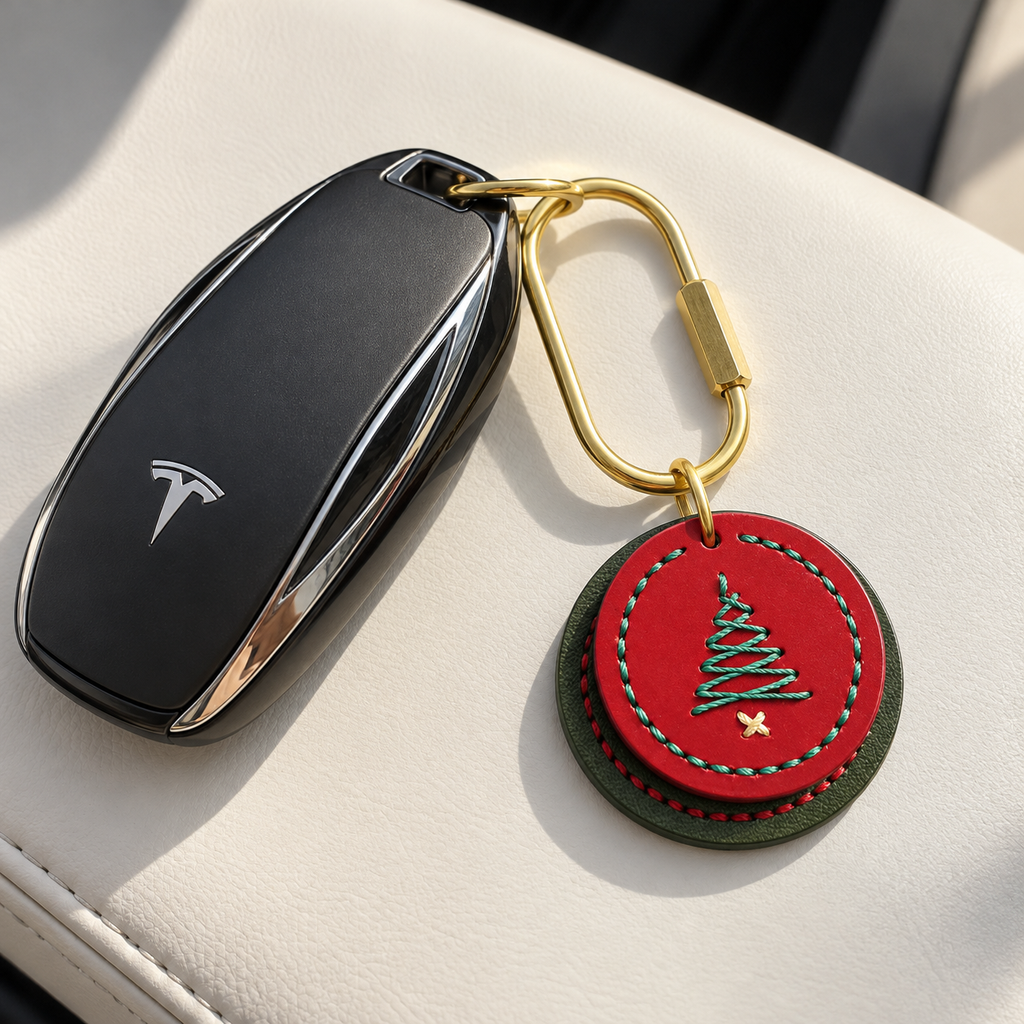 Red and green stitched cowhide Christmas tree charm attached to a car key with a brass clasp