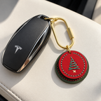 Red and green stitched cowhide Christmas tree charm attached to a car key with a brass clasp